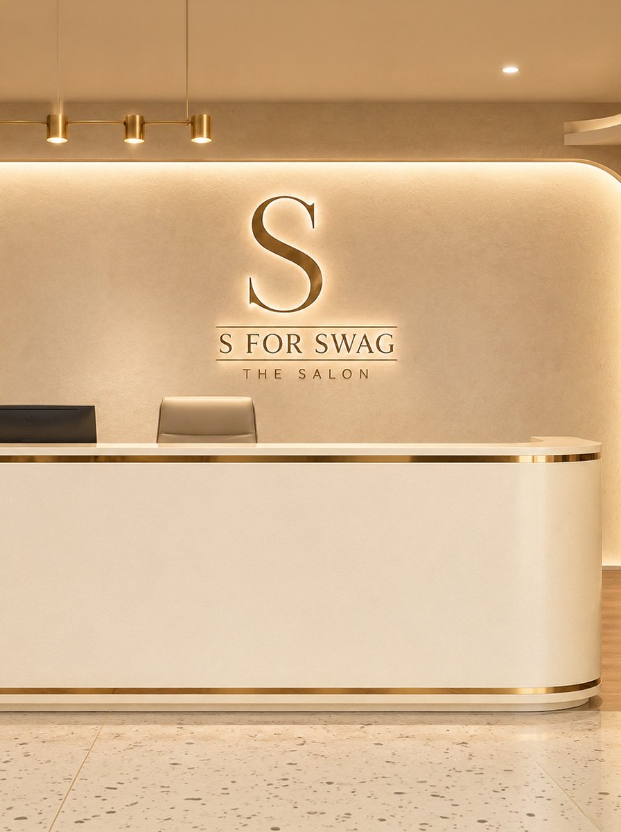 Cream and gold reception desk beneath an illuminated S For Swag salon sign